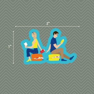 Op de afbeelding: Een gestanste sticker met twee personen die op bagage zitten en boeken lezen. De persoon links draagt een geel topje en een blauwe broek, de persoon rechts een blauw shirt en een beige broek. De sticker meet 5,08 cm bij 2,54 cm.