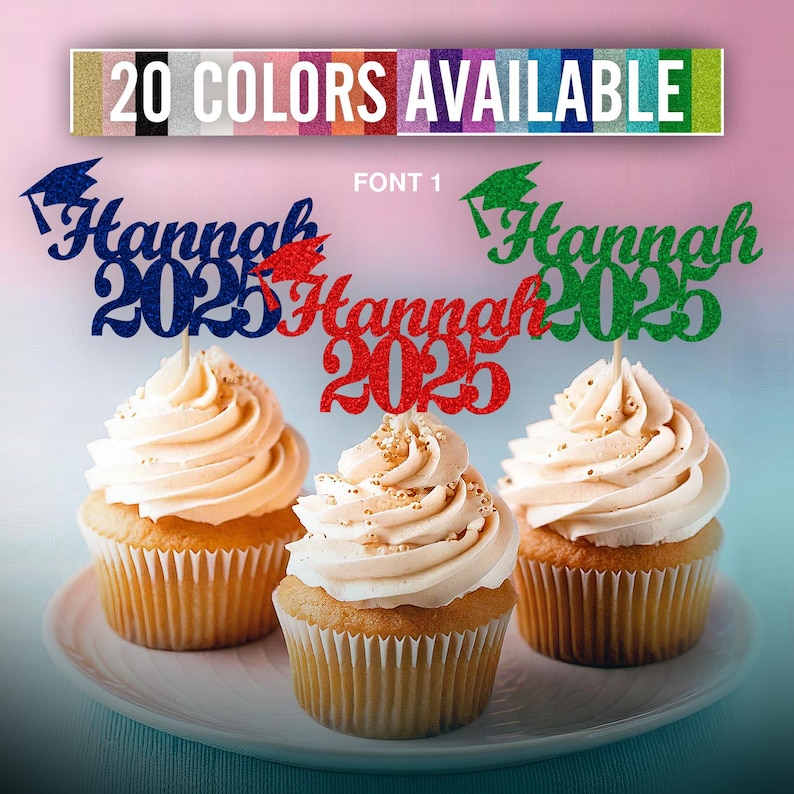 May include: Three cupcakes with graduation themed toppers that say "Hannah 2025" in blue, red, and green glitter. The toppers are decorated with a graduation cap and the year 2025. The cupcakes are frosted with white frosting and have a light brown cupcake liner.