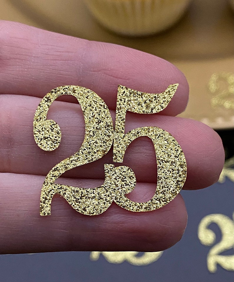 May include: Gold glitter number 25, a decorative topper for cakes or other crafts.