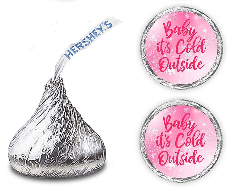 May include: Two pink and white round stickers with the text "Baby it's Cold Outside" in white and pink lettering. The stickers are designed to be placed on Hershey's Kisses chocolate candies.