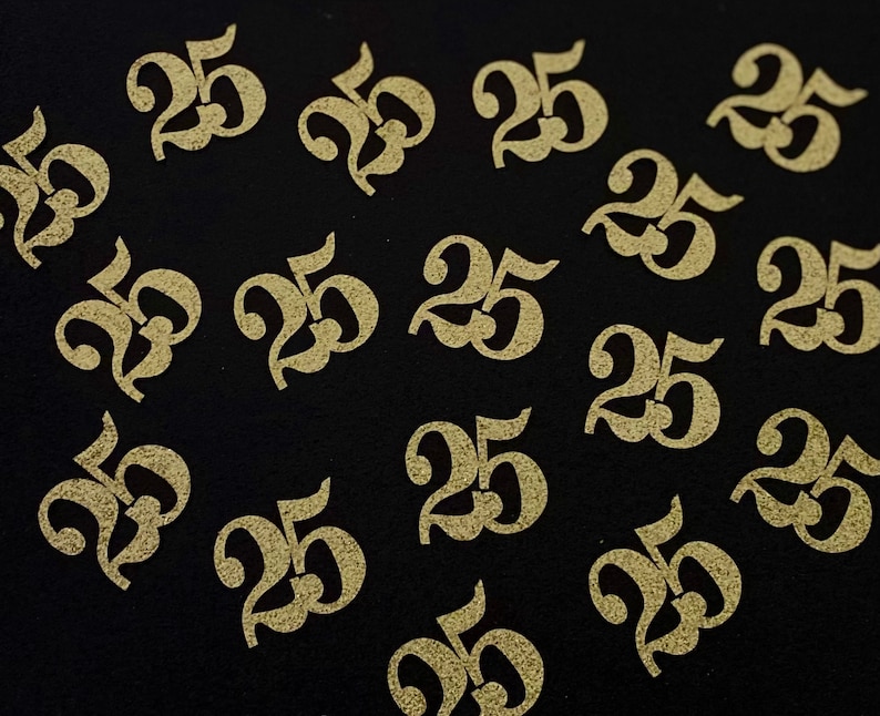 May include: A black background with multiple gold glitter-covered paper cutouts of the number 25.
