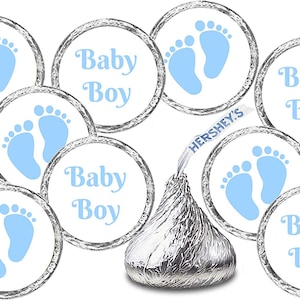 May include: Blue and white baby shower favor stickers with the text "Baby Boy" and a pair of blue footprints. The stickers are designed to be placed on Hershey's Kisses chocolate.