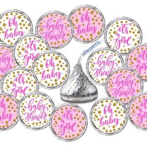 May include: Pink and gold baby shower favor stickers with various designs, including "Oh baby", "It's a girl", and "Baby shower".