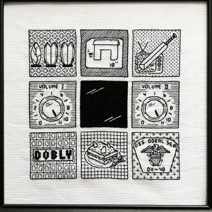 May include: Black and white cross-stitch embroidery in a black frame. The design features a television screen, volume knobs, a 'DOBLY' label, and a ship's insignia.