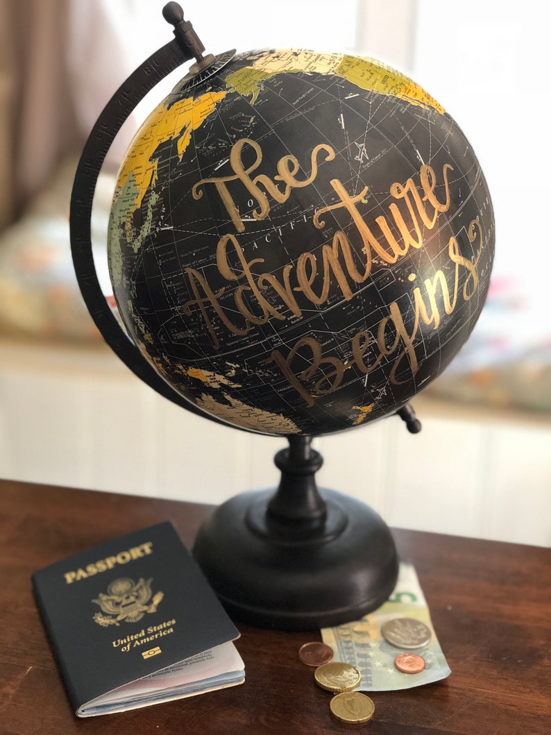 Black vintage style globes with "The Adventure Begins" hand-lettered on the front