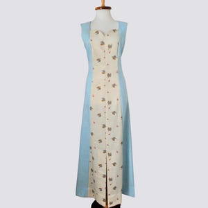 May include: A long, sleeveless dress with a light blue bodice and a white skirt with a floral pattern. The dress has a button-up front and a fitted silhouette.