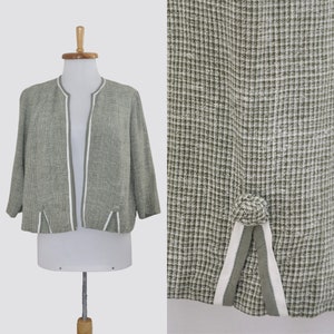 May include: A green and white checkered cropped jacket with white trim. The jacket has a collarless neckline and a front opening.