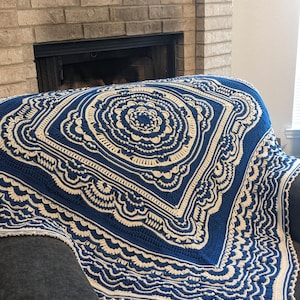 Könnte beinhalten: Eine quadratische, gehäkelte Decke in Marineblau und Creme. Die Decke hat ein detailliertes, kreisförmiges Design in der Mitte mit komplizierten Mustern und einem gewellten Rand. Der Text "Made With Love By Tasha" ist sichtbar.