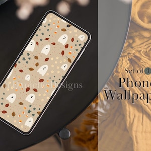 May include: A smartphone displays a Halloween-themed wallpaper with white ghosts, autumn leaves, and candy corn on a tan background. The phone is on a black surface. Text on the right says "Set of 4 Phone Wallpapers".