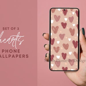 May include: A set of three phone wallpapers featuring a pattern of pink, red, and white hearts on a beige background. The text "Sarah Danielle Designs" is visible in the bottom right corner of the image.