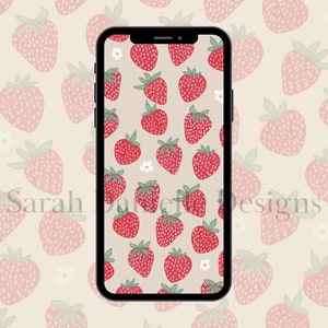 May include: A smartphone displaying a digital wallpaper with a pattern of red strawberries and white flowers on a light beige background.