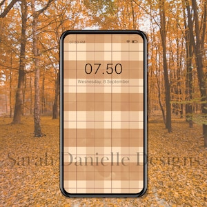 May include: A smartphone displaying a digital clock with the time 07:50 AM and the date Wednesday, 8 September. The phone's background is a brown and white checkered pattern. The phone is sitting on a bed of fallen autumn leaves.