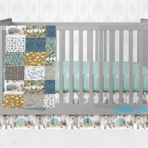 Könnte beinhalten: Ein graues Babybett mit einer weißen und blauen Patchwork-Decke, einem mintgrünen Spannbettlaken mit weißen Punkten und einem weißen und braunen gemusterten Bettrock mit dem Text "Little Love Landing".