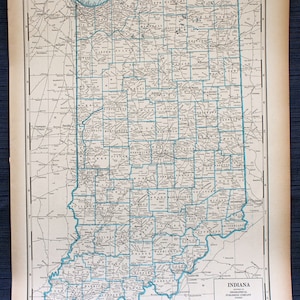 May include: A vintage map of Indiana, showing the state's counties and major cities. The map is printed in black and white on a cream-colored paper. The map is titled "Indiana" and includes a legend and scale of miles.