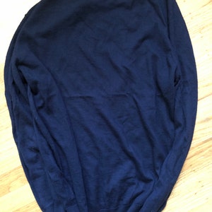 K&ouml;nnte beinhalten: Ein dunkelblauer Langarm-Pullover aus weichem Strickstoff.