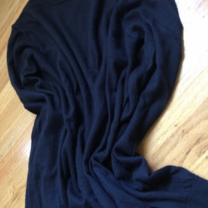 K&ouml;nnte beinhalten: Ein dunkelblauer Langarm-Pullover aus weichem, gestricktem Stoff.