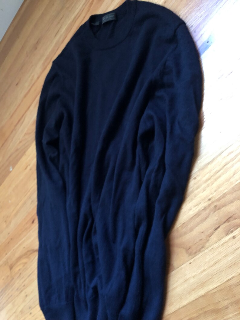 K&ouml;nnte beinhalten: Ein dunkelblauer Langarm-Pullover mit Rundhalsausschnitt.