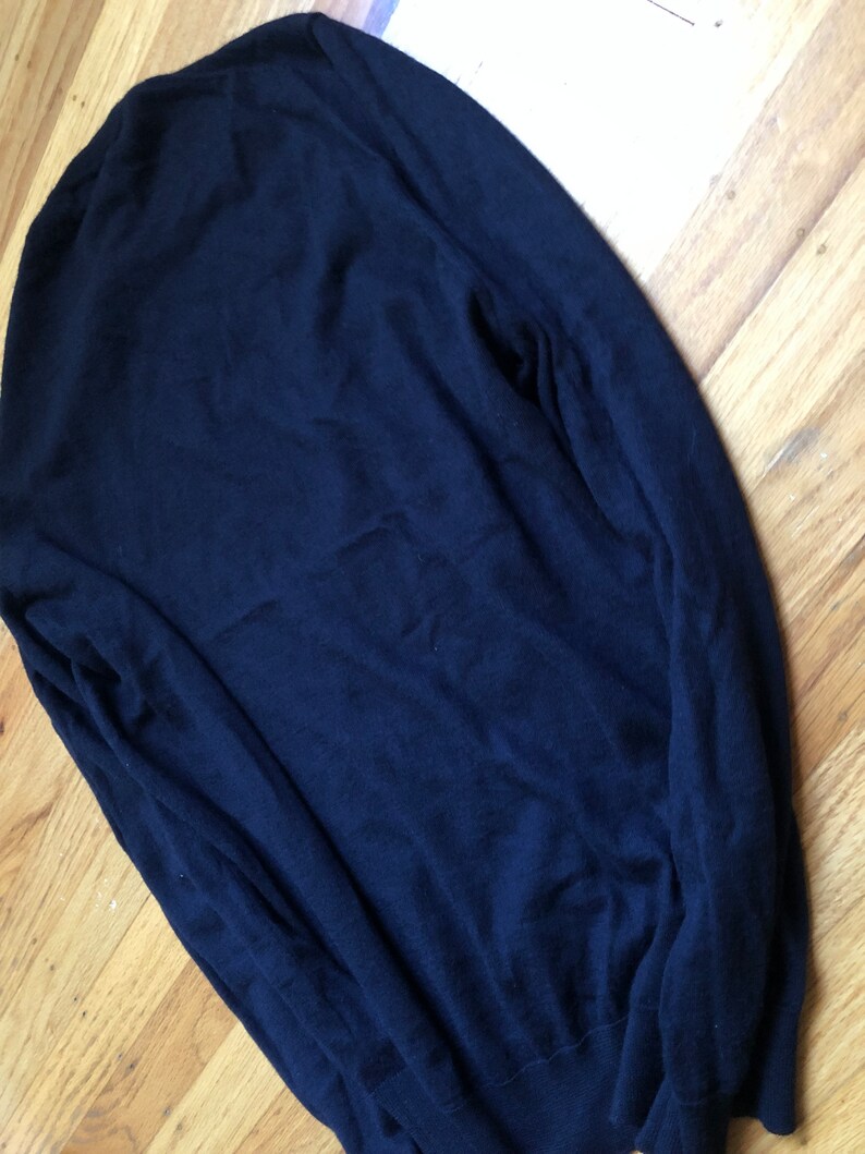 K&ouml;nnte beinhalten: Ein dunkelblauer Langarm-Pullover aus weichem, gestricktem Stoff.