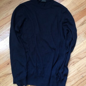 K&ouml;nnte beinhalten: Ein dunkelblauer Langarm-Pullover mit Rundhalsausschnitt.
