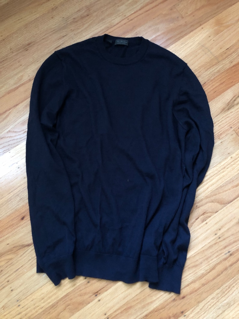 K&ouml;nnte beinhalten: Ein dunkelblauer Langarm-Pullover mit Rundhalsausschnitt.