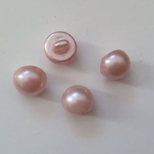 Pode incluir: Quatro botões rosa perolados com acabamento brilhante.