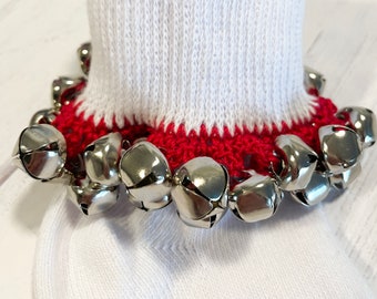 May include: White socks with a red crocheted cuff and a row of silver jingle bells attached.