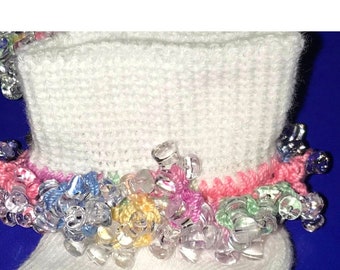 May include: White crocheted baby booties with a colorful beaded trim. The trim features pink, blue, green, and yellow beads.