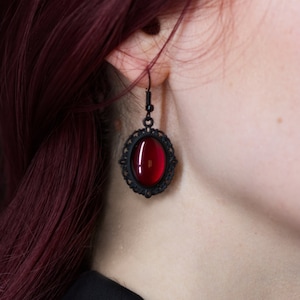 Pendientes colgantes ovalados decorados con piedras de vidrio de colores en bronce plateado negro como una joya noble para el día a día y como regalo de cumpleaños.
