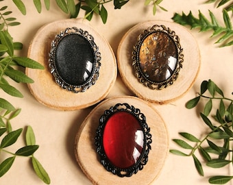 Oval brooch pendant with colored glass stones in black silver and bronze as cosplay or gothic jewelry as a gift