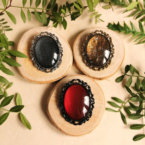 Oval brooch pendant with colored glass stones in black silver and bronze as cosplay or gothic jewelry as a gift