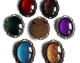 Ovale Brosche Wunschfarbe aus Glassteinen in Schwarz Silber und Bronze als Cosplay Schmuck und Gothic Accessoire