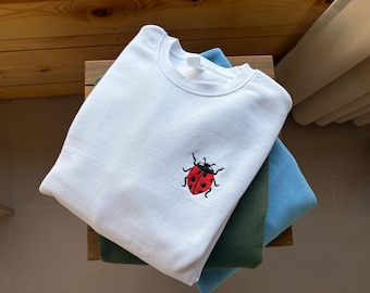 Sudadera bordada con minimariquita, diseño minimalista de insecto, suéter inspirado en la naturaleza.