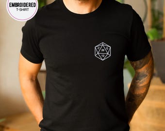 May include: A black t-shirt with a white embroidered image of a twenty-sided die.