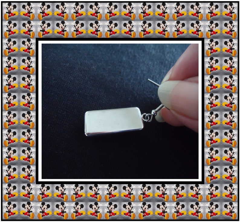 Peut inclure: Boucle d'oreille rectangulaire en argent avec une finition lisse et polie. La boucle d'oreille est pr&eacute;sent&eacute;e pendante &agrave; l'oreille d'une personne.