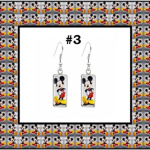 Peut inclure: Une paire de boucles d'oreilles pendantes en argent avec un charme en verre rectangulaire repr&eacute;sentant une image de dessin anim&eacute; de Mickey Mouse. Les boucles d'oreilles sont &eacute;tiquet&eacute;es #3.