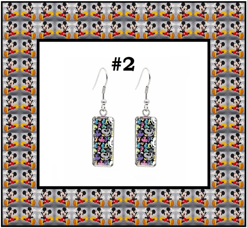 Peut inclure: Une paire de boucles d'oreilles pendantes en argent avec des breloques rectangulaires en verre. Les breloques pr&eacute;sentent un motif color&eacute; de t&ecirc;tes et de mains de Mickey Mouse. Les boucles d'oreilles sont &eacute;tiquet&eacute;es #2.