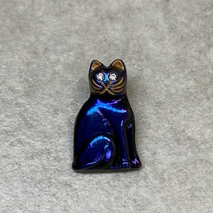 Könnte beinhalten: Eine kleine, blaue Glaskatzenfigur mit goldenen Akzenten und klaren Strasssteinen als Augen. Die Katze sitzt mit dem Schwanz um die Beine gewickelt.