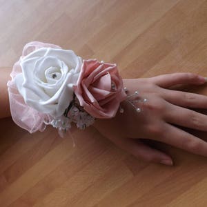 White and baby pink foam rose wrist corsage with diamante and sprays of pearls