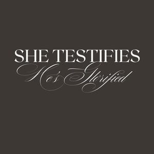 Pode incluir: Fundo cinza escuro com texto branco. As palavras "SHE TESTIFIES" estão em uma fonte serif. Abaixo, em itálico, diz "He's Glorified". O texto está centralizado.