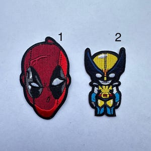 Peut inclure: Deux patchs brodés thermocollants représentant des personnages de super-héros. Le premier patch est rouge et représente la tête de Deadpool. Le deuxième patch est jaune et représente Wolverine dans une pose de super-héros.