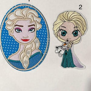 Op de afbeelding: Twee geborduurde patches met het personage Elsa uit de film Frozen. Eén patch is een ovaal portret met een blauwe stippelachtergrond. De andere patch toont Elsa die Olaf vasthoudt.
