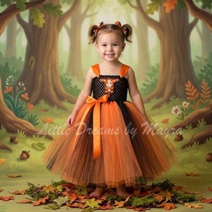 May include: A sleeveless dress featuring a black crocheted bodice with a central orange and brown fox-themed applique, a wide orange satin waist ribbon, and a multi-layered tulle skirt in alternating shades of vibrant orange and dark brown.