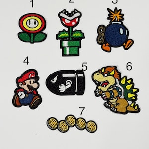 May include: A collection of seven embroidered patches featuring video game characters and items labeled 1 through 7. The designs include a fire flower, a piranha plant, a bomb, a plumber character, a bullet, a turtle-like creature, and gold coins.