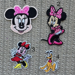 Puede incluir: Cuatro parches bordados para planchar con personajes de dibujos animados. Los parches están numerados del 1 al 4. El parche 1 es un primer plano de la cara de Minnie Mouse con un lazo rosa. El parche 2 muestra a Minnie Mouse con un vestido rojo con lunares blancos y un lazo rosa. El parche 3 muestra a Minnie Mouse con un vestido rojo con un lazo rojo. El parche 4 muestra a Pluto el perro en un esquema de colores amarillo y marrón.