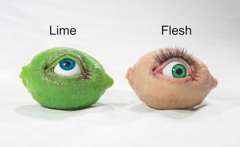 May include: Two limes with eyes, one lime is green with a blue eye and the other lime is flesh colored with a green eye. The limes are labeled "Lime" and "Flesh".