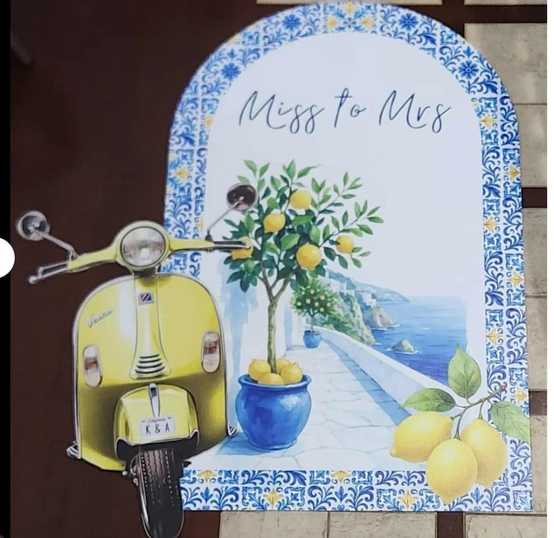 May include: A decorative sign featuring a yellow scooter and a coastal scene with a lemon tree in a blue pot. The sign has the text "Miss to Mrs" and is framed with blue and white patterned borders.