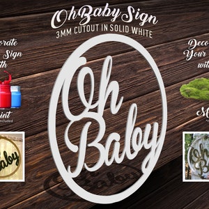 May include: White wooden "Oh Baby" sign with a 3mm cutout. The sign is in the shape of a circle and has a cursive font. The sign can be decorated with paint or moss.