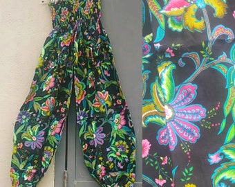 Harem style trousers. Wide legged with smocked waist and elasticated ankle. Tropical flower print on black background