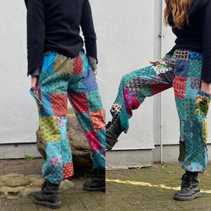 May include: Patchwork pants in shades of blue, green, red, and pink. The pants feature a variety of geometric and floral patterns, with a relaxed fit and elastic waistband. The pants are shown with black boots.