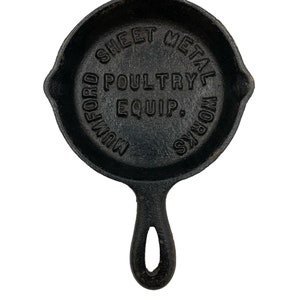 Puede incluir: Sart&eacute;n de hierro fundido negro con mango. La sart&eacute;n tiene las palabras "Wm. Oxford Sheet Metal Works Poultry Equip." grabadas en el lateral.
